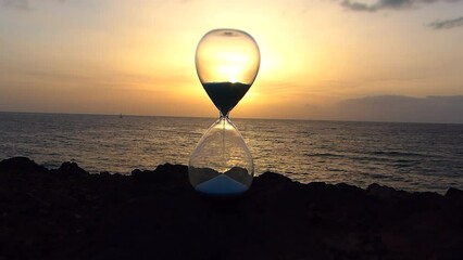 Time lapse of an hourglass at sunset on a beach in Santa Cruz de Tenerife - Powered by Adobe