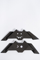 Halloween bats, origami DIY paper crafts on white background, top view