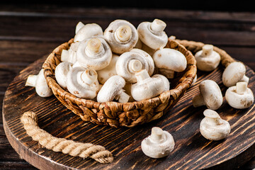 Fototapeta na wymiar Fresh mushrooms in a basket on a wooden tray. 