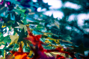 Garlands and stars made of foil on the Christmas tree.