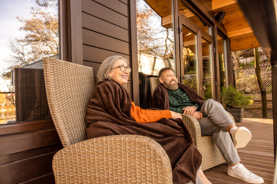 Two people sitting in the armchairs on the cottage terrace