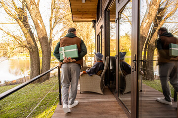 Man hiding a gift and a woman looking anticipated and excited