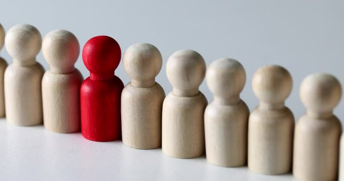 Red man standing among wooden ones in crowd closeup 4k movie slow motion