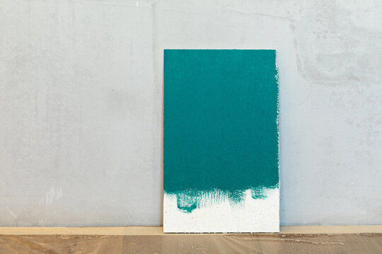 Green color sampler at a blank plaster wall