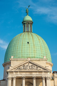 View over San Simeone Piccolo Catholic Church, its top dome with statue of Roman man pointing with hand towards sky in Venice, Italy.