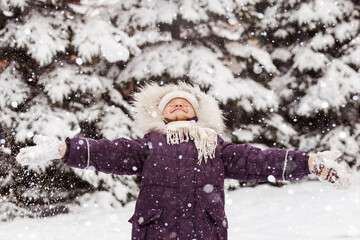 Fototapeta premium Happy Winter Children Holidays. Little Girl Child Smiling Having Fun Playing Enjoying Snow Winter in Snowy Background.