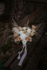 Beautiful wedding bouquet in vintage style. Boho bridal bouquet composed of lisianthus, pampas grass, roses and dried flowers. Wedding day.