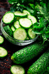 Sliced and whole cucumbers on the table.