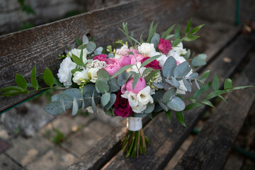 Fototapeta na wymiar Wedding bouquet composed of roses, ozothamnus, freesia and eucalyptus. Pink bridal bouquet. Wedding day.