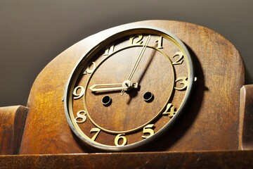 Vintage desktop mechanical clock in a wooden case with gilded numerals and hands