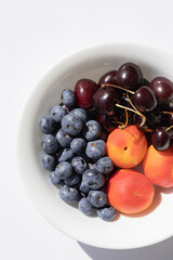 Organic ripe berries and fruits in the white bowl. Close up
