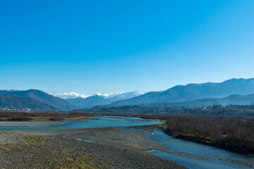 Wide angle view of Chokhori river valley and mountainous range in the distance. Georgia landscape.