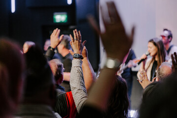 Hands in the air of people who praise God at church service - 564262325