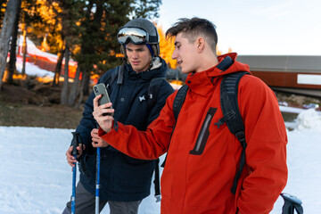 Fototapeta na wymiar Two boys in ski clothes looking at the phone.