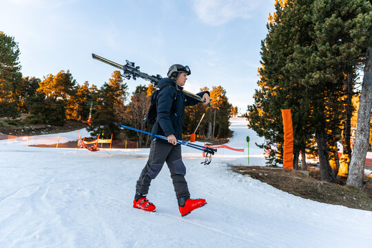 Boy walking with ski equipment.