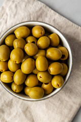 Marinated Green Pitted Olives in a Bowl, top view. Flat lay, overhead, from above.