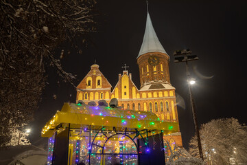 The Cathedral of Kaliningrad with street cafe on the foreground in the winter night - 564265958