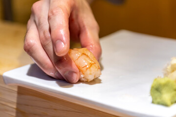 일식 스시 초밥을 손님에게 내어주는 요리사의 손