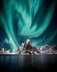 Northern lights, Aurora borealis over amazing landscape in Lofoten, Norway  with mountains in...