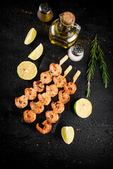Grilled shrimp on a stone board with pieces of lime. 