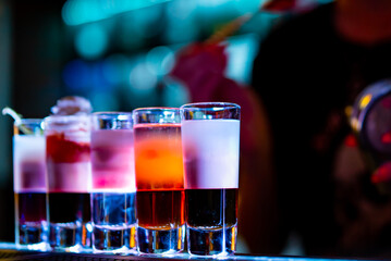 bartender making collection of colorful shots. Set of cocktails at the bar