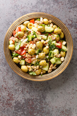 Green olive salad yesil zeytin salatasi with vegetables closeup on the plate on the table. Vertical top view from above
