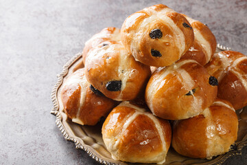 Hot cross bun is a spiced sweet bun made with raisins marked with a cross on the top, and...