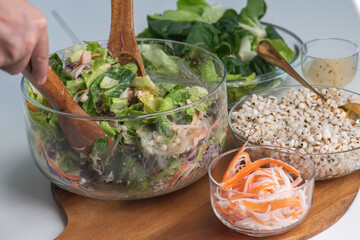 Hand chef mix fresh baby cos salad millet Crab Stick and pour salad dressing in wood blow. Organic Vegetables mix lunch with green salad In bowl. Breakfast fresh salad and clean vegetable