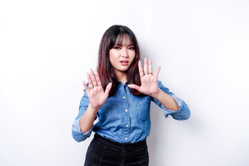 Young Asian woman isolated on white background, looks depressed, face covered by fingers frightened and nervous.