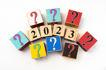 2023 with question mark written on wooden blocks isolated on white background with copy space in...