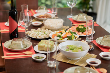 Plates with traditional dishes on table served for Tet celebration