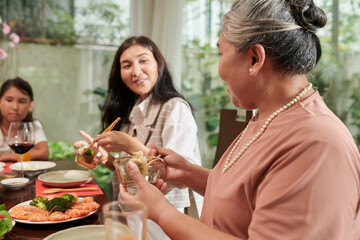 Happy family eating traditional dishes at Tet celebration at home