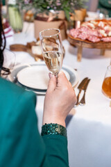 a woman holds a glass of champagne in her hand in a restaurant