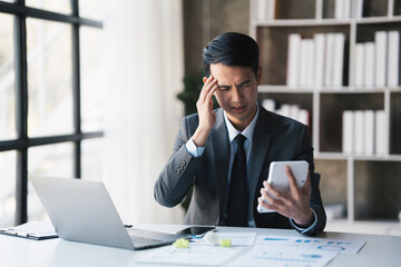 Handsome Asian businessman concentrate on his project while working in his office room.