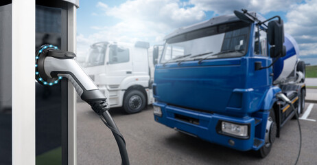 Electric vehicles charging station on a background of a trucks. Concept