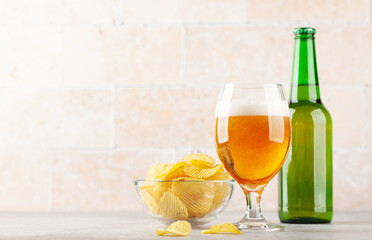 Beer glass, beer bottles and potato chips