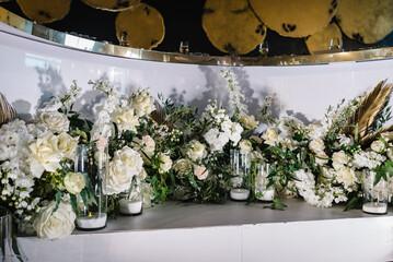 Festive table, wooden arch, stands decorated with composition of  flowers and greenery, candles in the banquet hall. Table newlyweds in the banquet area on wedding party.
