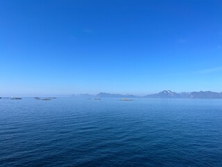 Obraz premium Blue calm ocean bay horizon, small rocky islands, blue sky