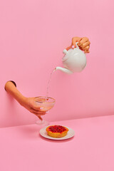 Food pop art photography. Female hand sticking out pink paper and pouring champagne from tea kettle into glass over delicious berry tart. Art. Complementary colors. Copy space for ad, text