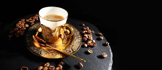Espresso coffee in golden cup rotating on black background. Luxurious elegance style