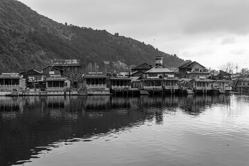 Fototapeta na wymiar Kashmir, Srinagar India - Jan 10 2023: Popular Srinagar Houseboats in Dal Lake. Colorful Shikara ride floating in Dal Lake aka Nigeen lake. Mountain range in Srinagar. Couple Honeymoon Destination. 