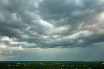 Landscape of dark ominous clouds forming on stormy sky before heavy thunderstorm over rural town...