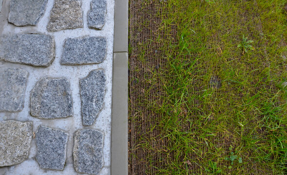 railing at the bridge with vertical fence bars anchored to the ground with four concrete screws. plastic caps, cobblestone, stone, paving, cable, edge, next to, pillar, fixing, point, urban, , lawn