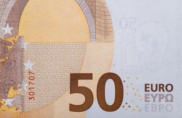 A fragment of a 50 euro banknote with close-up figures.