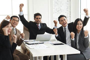 Happy success group of businesspeople during presentation. Colleagues cheering and smiling.