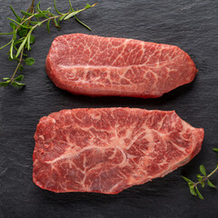 Top Blade beef steaks on black background. Fresh raw meat. Top view.