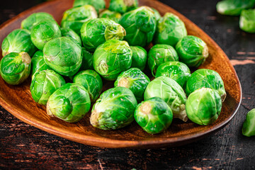Fresh Brussel cabbage on a wooden plate. 