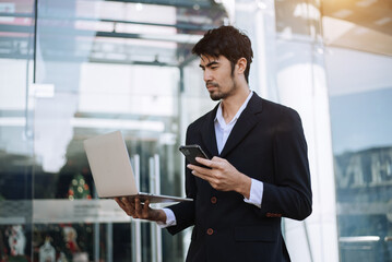 Fototapeta premium Asian businessman holding laptop.Office worker at business center