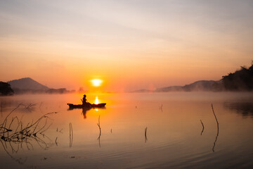 Women on kayak rows in the reservoir during the sunrise, Harirak forest park Huai Nam Man reservoir...