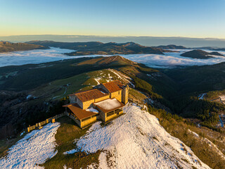 Hermitage in Kolitza mount in Balmaseda at dawn with snow, Basque Country, Spain drone view